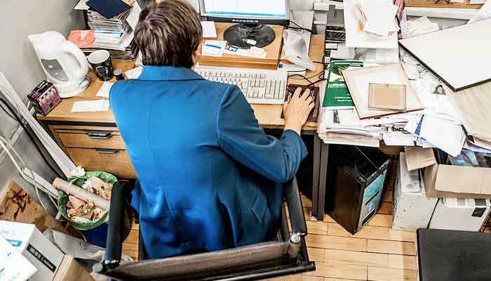 An employee with a messy office area